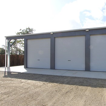 Triple bay garage with a carport on the side