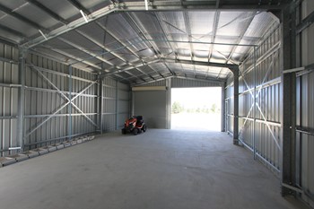Inside of a double bay garage. One side is open the other has a roller door.