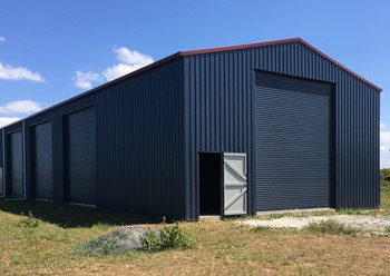 Big farm shed in the color "Deep Ocean" with gutters in "Manor Red"